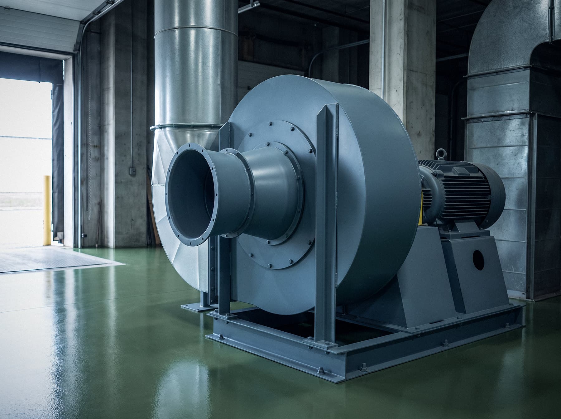 Illustrative image: industrial centrifugal blower with an electric motor on a steel base frame
